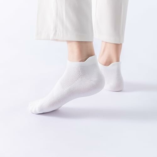 Person wearing white ankle socks with white pants.